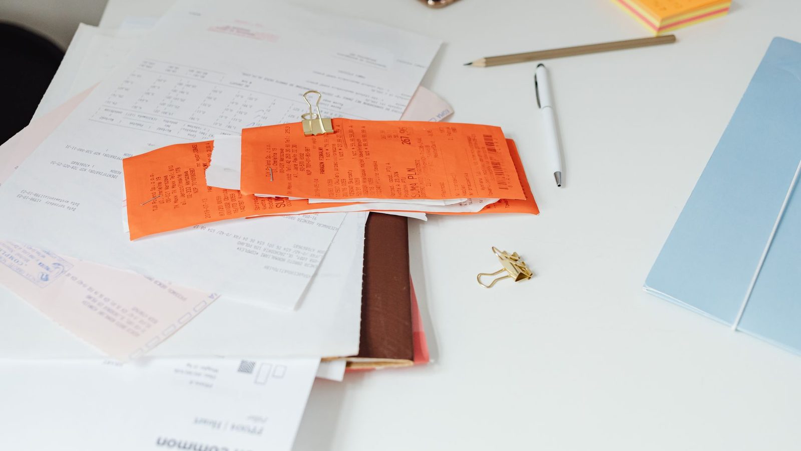 A tidy desk with receipts, documents and stationery, arranged for a claim.