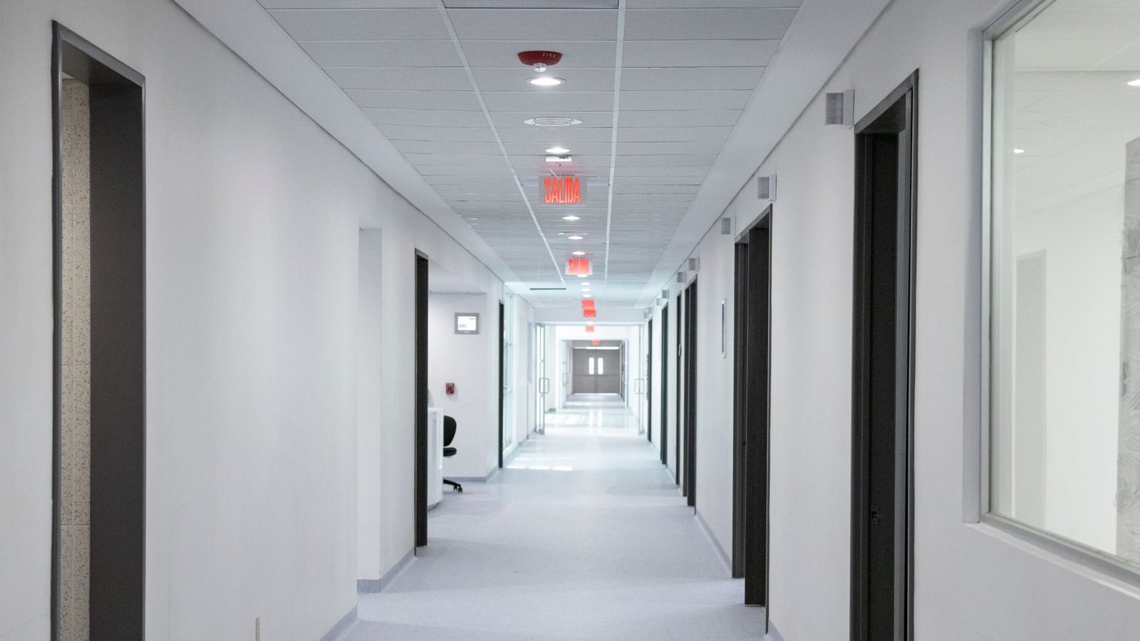 An empty, brightly lit hospital corridor.