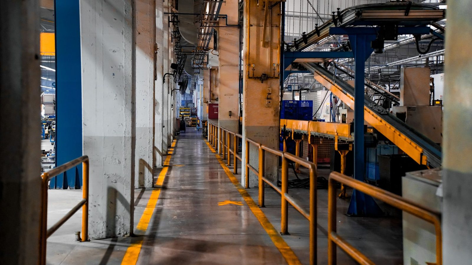 The interior of a modern factory, showing industrial machinery and conveyor systems.