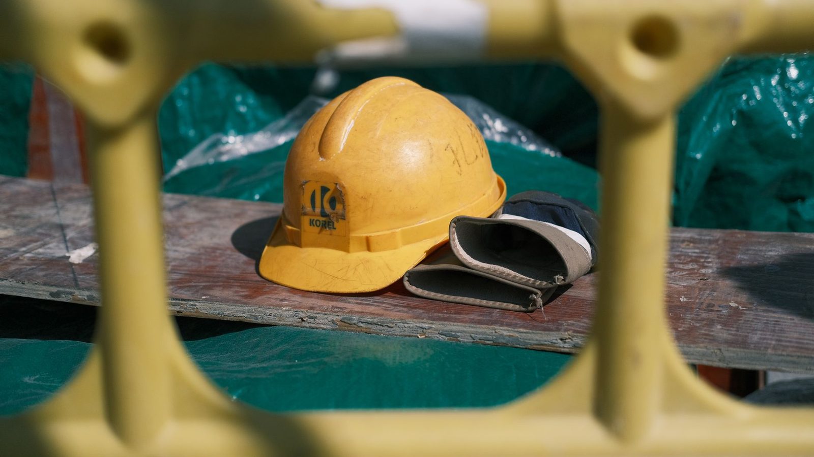 A yellow safety helmet resting on a workbench at a building site.